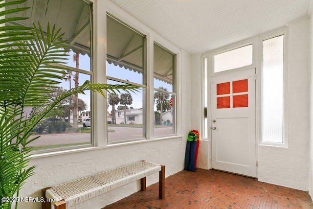 entryway featuring a textured wall, brick floor, and radiator