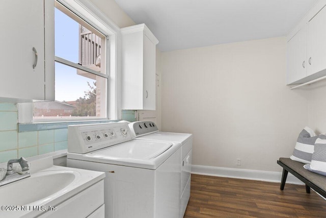 laundry room featuring washer and dryer, dark wood-style flooring, cabinet space, and baseboards