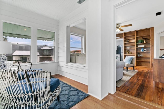 interior space with built in shelves, visible vents, and wood finished floors