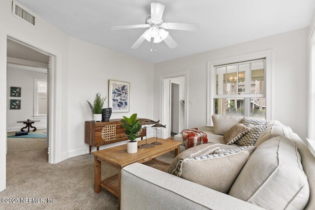 living area with baseboards, carpet, visible vents, and a ceiling fan