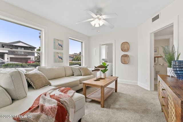 living room with light carpet, ceiling fan, visible vents, and baseboards