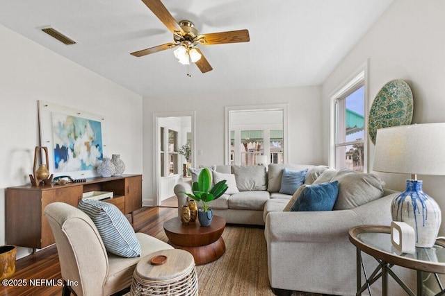 living area with dark wood-style floors, ceiling fan, and visible vents