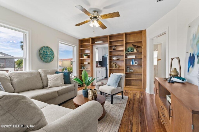 living room with dark wood-type flooring and a ceiling fan