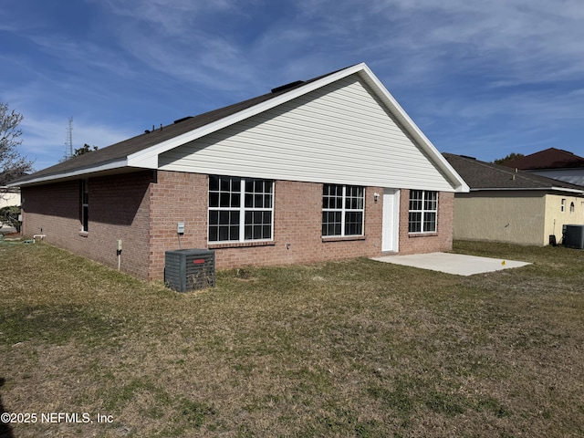 rear view of property with a yard, central AC unit, and a patio area