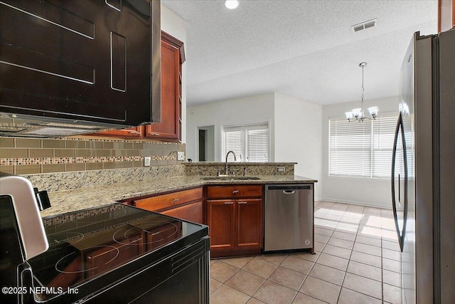 kitchen featuring appliances with stainless steel finishes, sink, stone countertops, backsplash, and light tile patterned floors