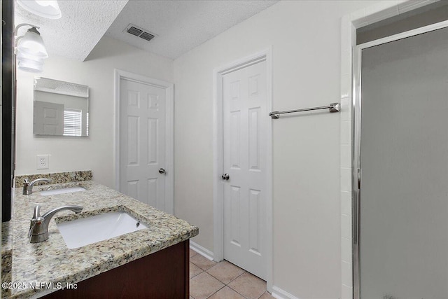 bathroom featuring an enclosed shower, a textured ceiling, tile patterned floors, and vanity