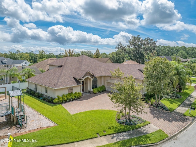 view of front of house with a garage, a playground, and a front lawn