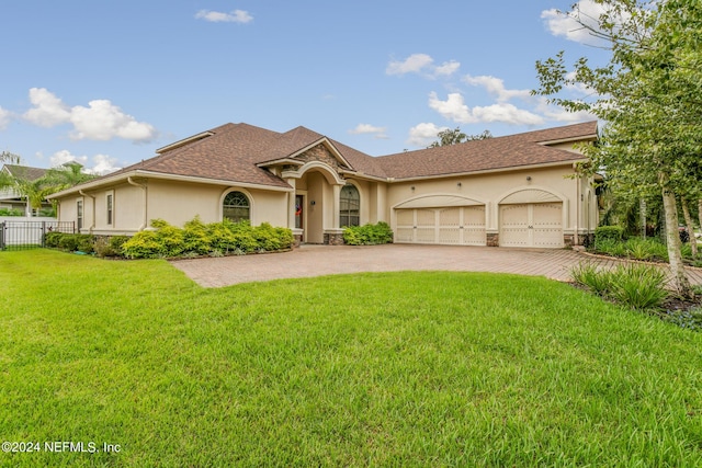 mediterranean / spanish home featuring a front lawn and a garage