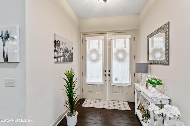 foyer entrance featuring a textured ceiling, french doors, a wealth of natural light, and dark hardwood / wood-style floors