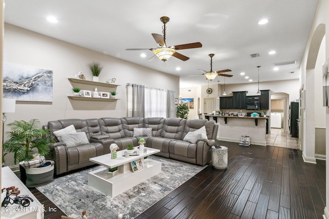 living room with washer / clothes dryer, ceiling fan, and dark hardwood / wood-style flooring