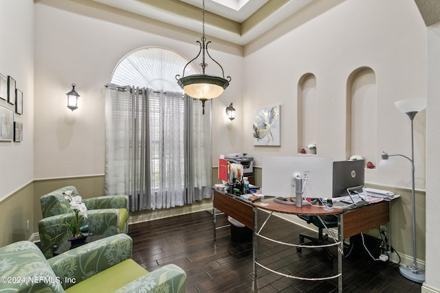 office space featuring a tray ceiling and dark wood-type flooring