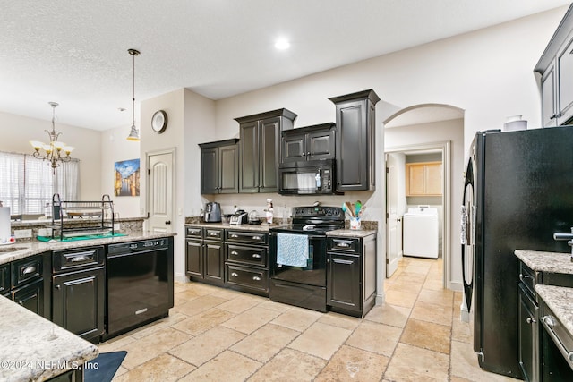 kitchen featuring black appliances, pendant lighting, washer / dryer, a textured ceiling, and an inviting chandelier