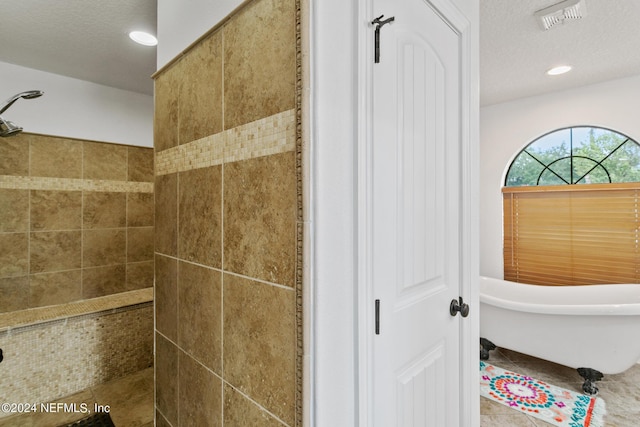 bathroom with tile patterned flooring, a textured ceiling, and shower with separate bathtub