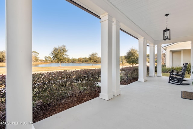 view of patio / terrace with a water view and covered porch