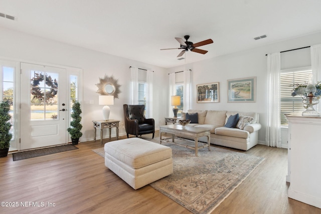 living room with light wood-type flooring and ceiling fan