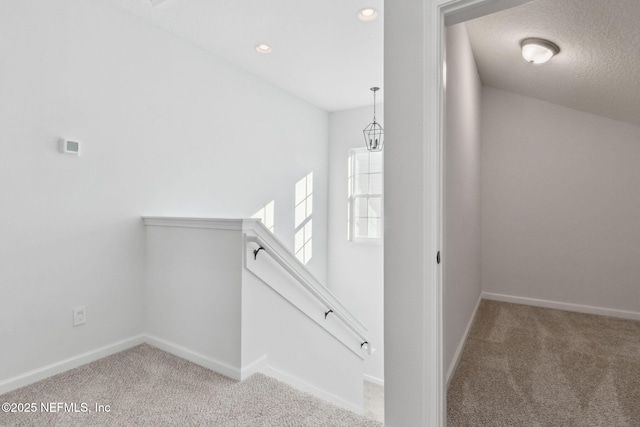 corridor featuring a textured ceiling and carpet floors