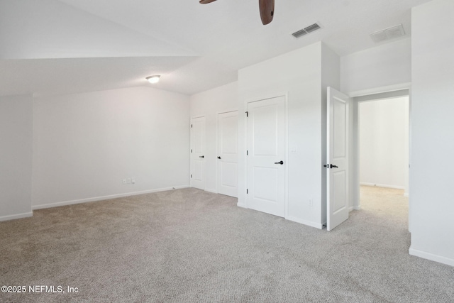 unfurnished bedroom with ceiling fan, light colored carpet, and lofted ceiling