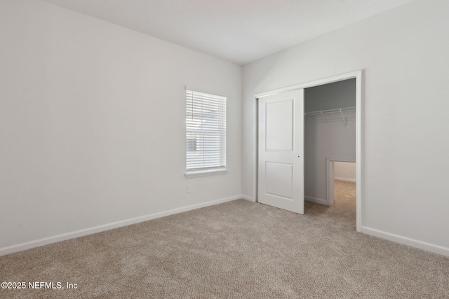 unfurnished bedroom featuring light carpet and a closet