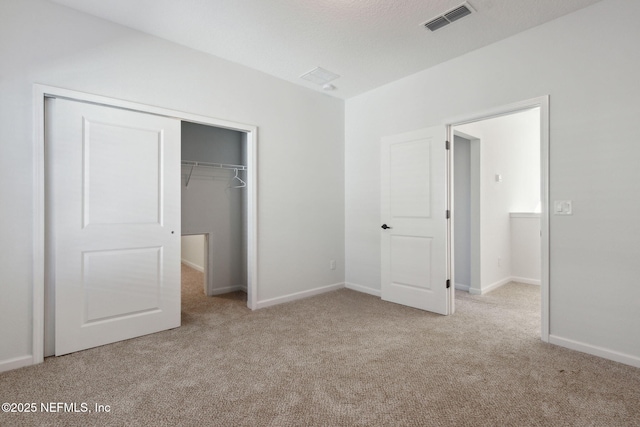 unfurnished bedroom featuring a closet and light colored carpet