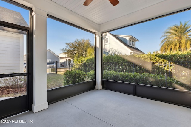 unfurnished sunroom featuring ceiling fan