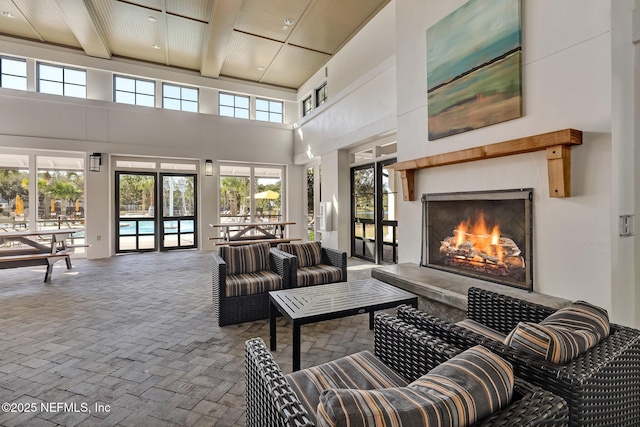 living room with beam ceiling and a high ceiling