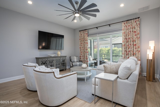 living room with wood-type flooring and ceiling fan