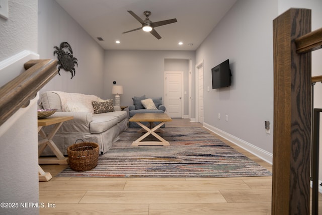 living room featuring light hardwood / wood-style flooring and ceiling fan