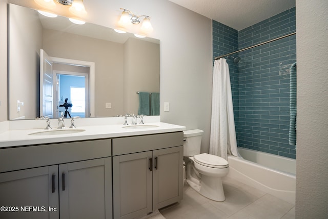 full bathroom with shower / tub combo with curtain, vanity, tile patterned floors, and toilet