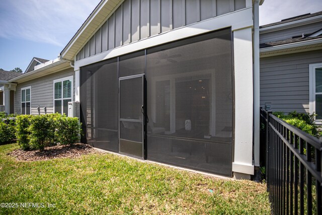 view of side of property with a yard and a sunroom