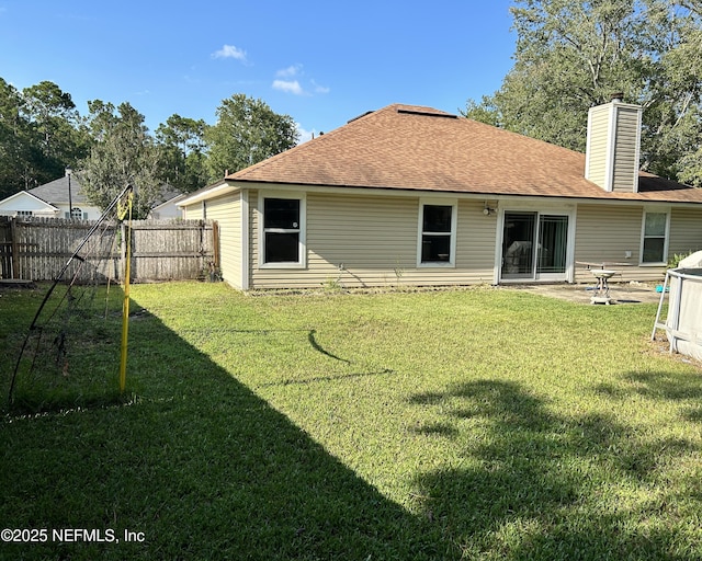 back of house featuring a patio and a yard