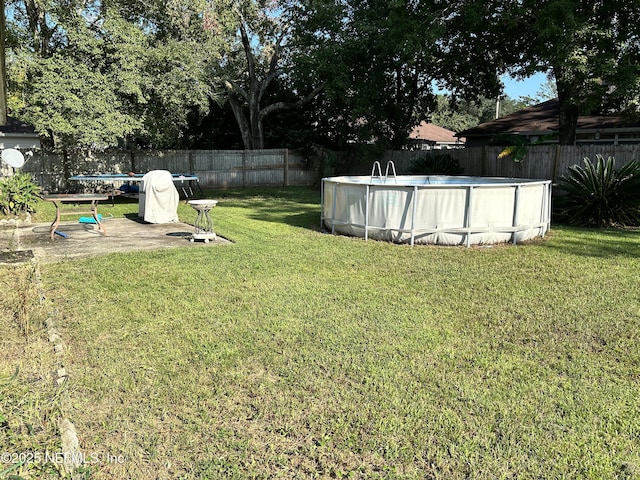 view of yard with a trampoline and a fenced in pool