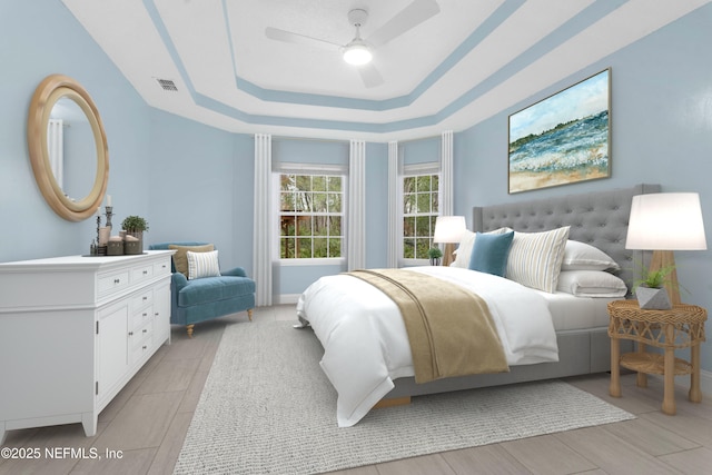 bedroom with ceiling fan and a tray ceiling