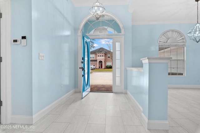 entrance foyer with a chandelier and ornamental molding