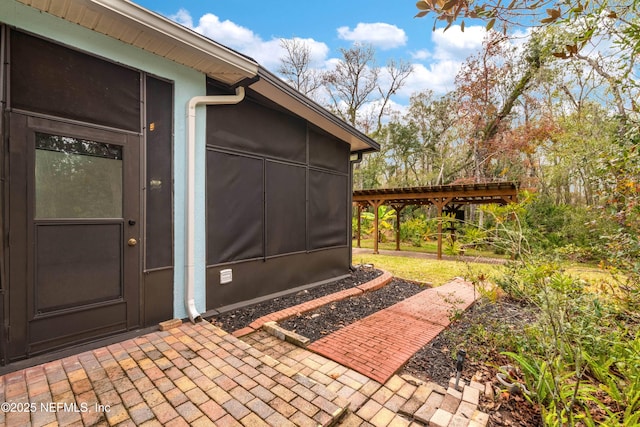 view of exterior entry featuring a pergola