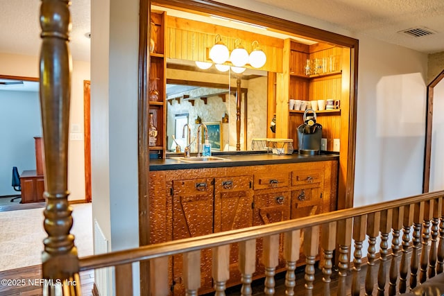 bar with a textured ceiling and sink