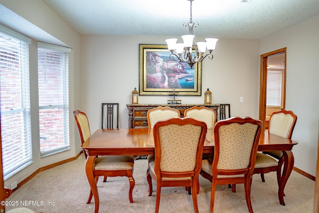 dining area with light colored carpet, a wealth of natural light, an inviting chandelier, and a textured ceiling