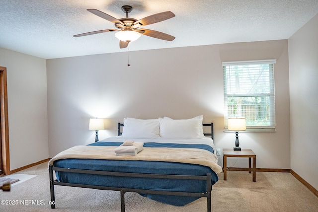 carpeted bedroom featuring a textured ceiling and ceiling fan