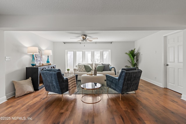 living room with ceiling fan, dark hardwood / wood-style floors, and a textured ceiling