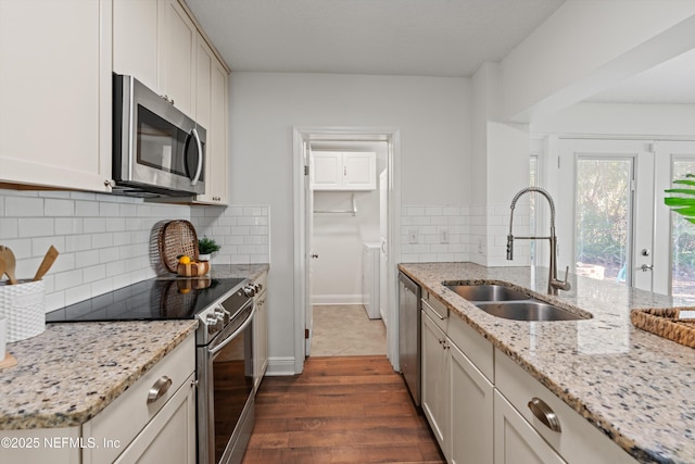 kitchen featuring sink, light stone counters, white cabinetry, appliances with stainless steel finishes, and dark hardwood / wood-style flooring