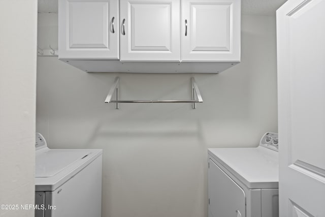 washroom featuring cabinets and washing machine and clothes dryer