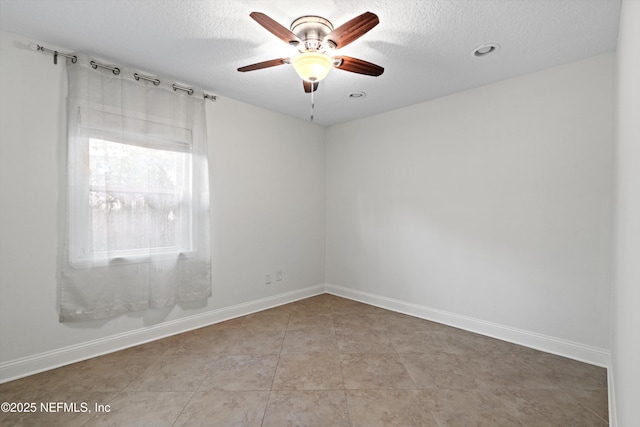 tiled spare room with ceiling fan and a textured ceiling