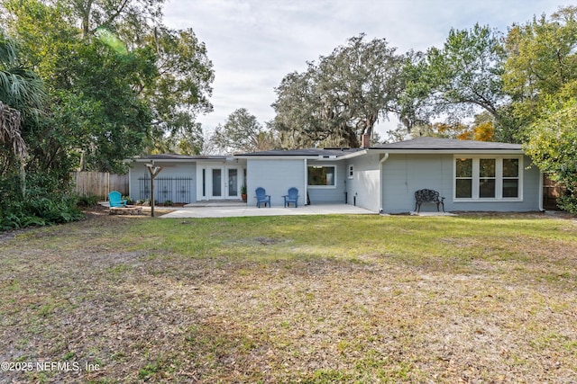 rear view of property with a patio area and a lawn