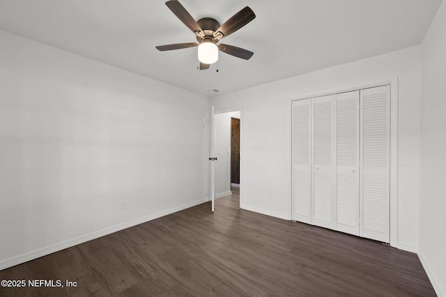 unfurnished bedroom with dark hardwood / wood-style flooring, a closet, and ceiling fan