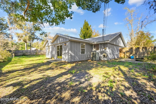 back of house featuring central AC and a yard