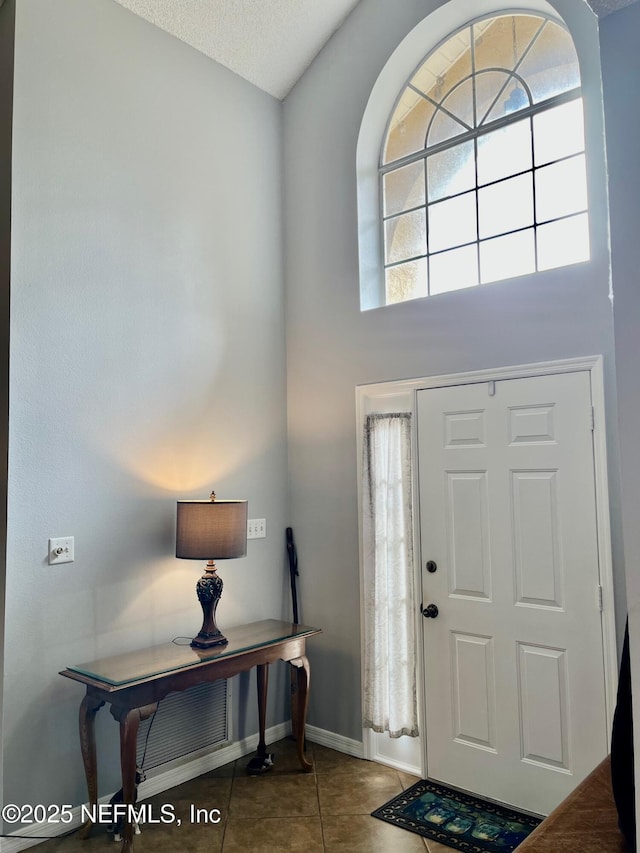 tiled entryway with a high ceiling