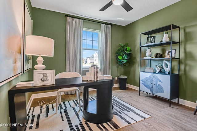 office space with a ceiling fan, baseboards, and wood finished floors