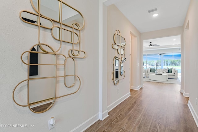 corridor with visible vents, baseboards, wood finished floors, and recessed lighting