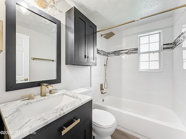 full bathroom with toilet, tiled shower / bath combo, vanity, and a textured ceiling