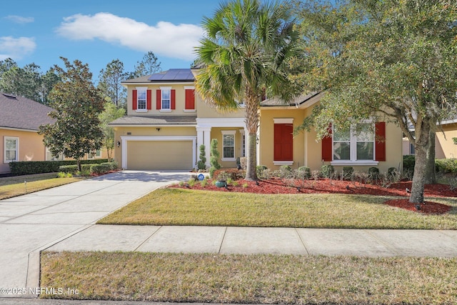 view of front facade with a garage, a front yard, and solar panels