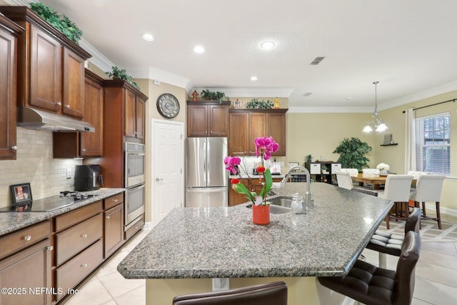 kitchen featuring sink, a kitchen breakfast bar, an island with sink, and appliances with stainless steel finishes